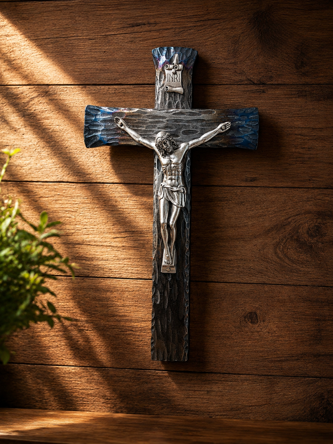 Hand-forged steel wall crucifix displayed in a warm Catholic home, handcrafted in the USA by The Catholic Blacksmith.