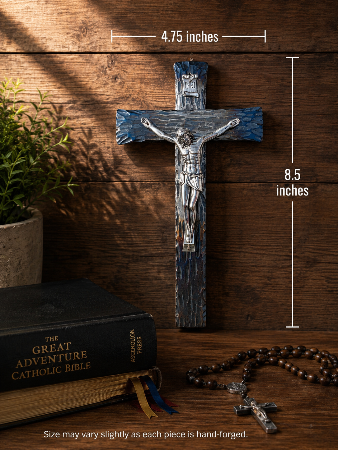 Hand-forged steel wall crucifix shown with a Great Adventure Catholic Bible for size comparison.